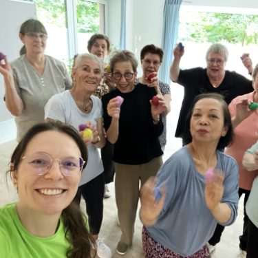 Eine Gruppe von Frauen, die zusammen mit bunten Bällen lächeln und posieren.